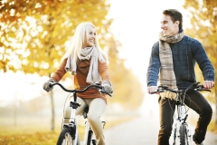 Beautiful couple rides bikes on a beautiful autumn day.