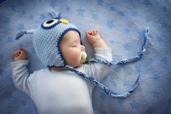 4 month old baby in owl sleeping on blue blanket